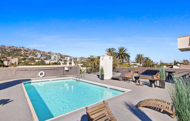 a swimming pool on a roof with a city in the background