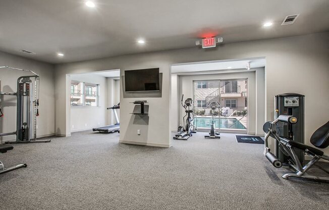 a gym with exercise equipment and a television in a building