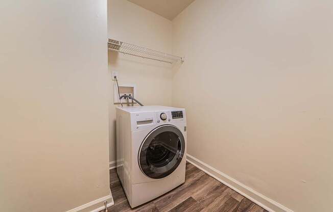 A washing machine is sitting in a corner of a room.