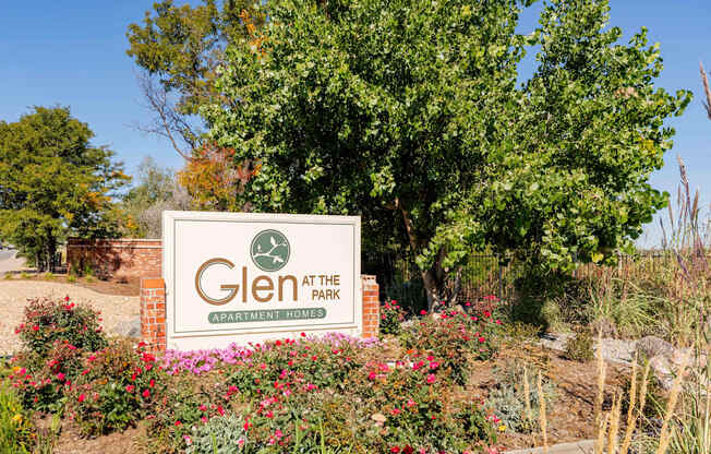 a sign for glen at the park in front of a tree