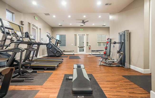 A gym with treadmills, elliptical machines, and weightlifting equipment.