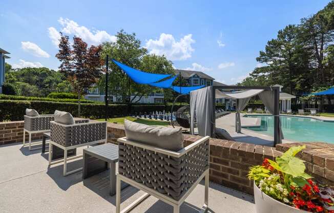 a patio with chairs and a pool in a backyard