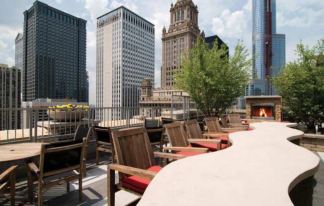 a rooftop patio with tables and chairs and a fire pit