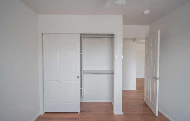 an empty hallway with white doors and a closet