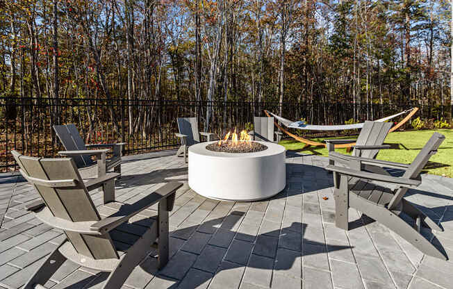 A fire pit surrounded by chairs on a patio.