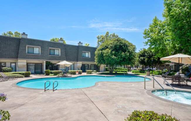 a swimming pool with umbrellas and a building in the background