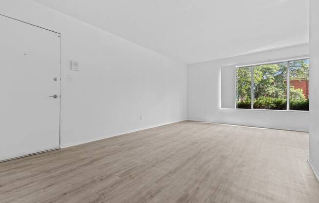 a bedroom with hardwood floors and white walls