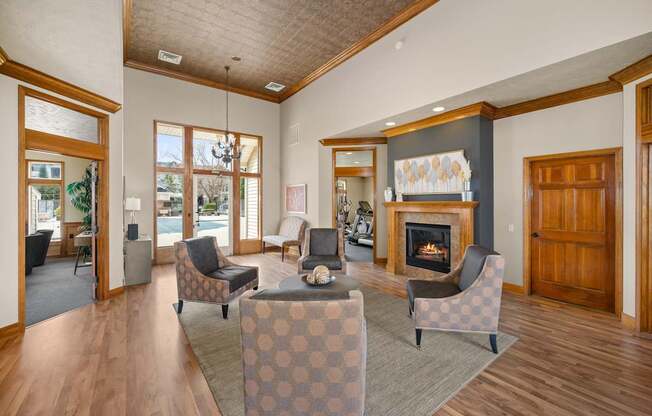 A living room with a fireplace and a checkered ottoman.