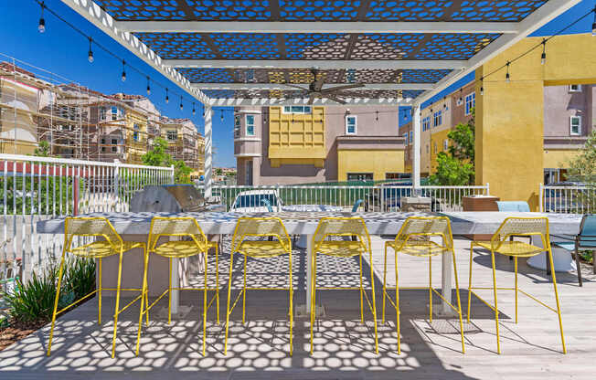 A patio with yellow chairs and a table.