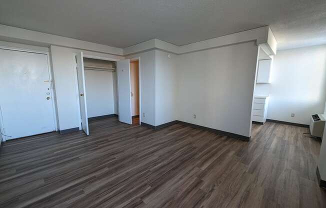 an empty living room with wood floors and white walls