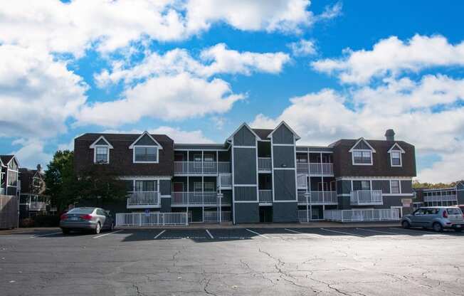a large apartment building with a parking lot in front of it