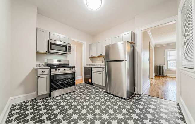 A kitchen with a black and white tiled floor.