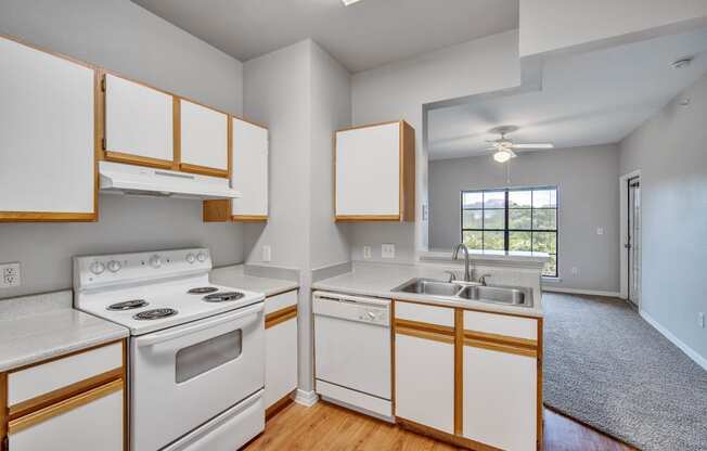 an empty kitchen with white appliances and wooden cabinets