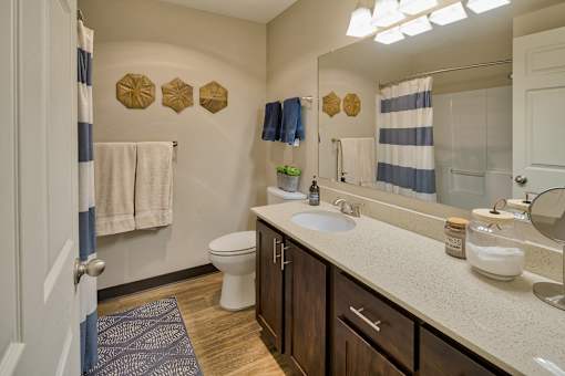 A bathroom with a white toilet, a sink, and a mirror.