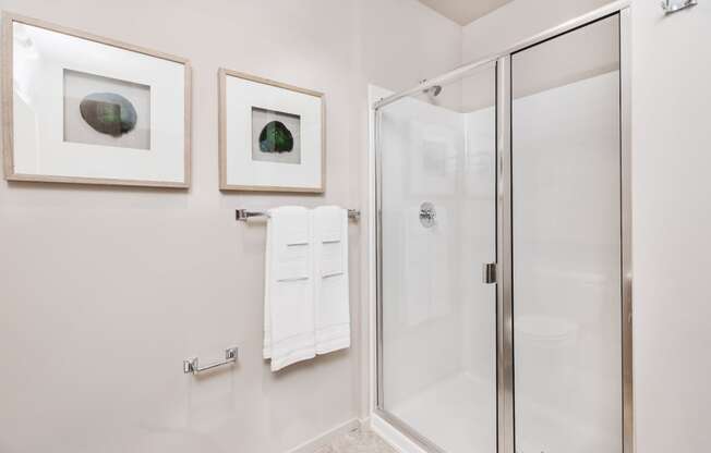bathroom with a glass shower and two pictures on the wall at The Hayes on Stone Way, Washington, 98103
