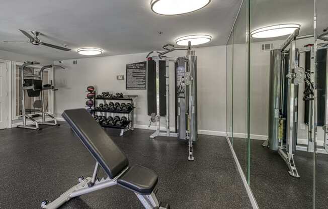 a gym with exercise equipment and mirrors in a home