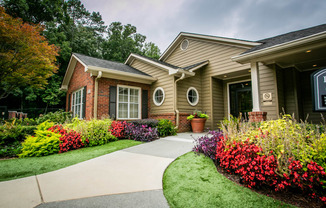 a house with a sidewalk in front of it and a garden