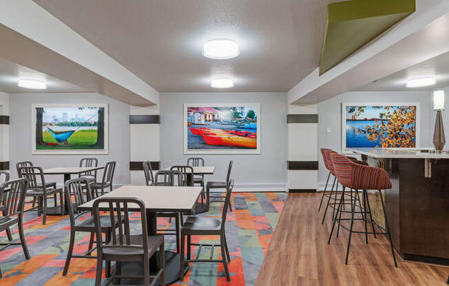 a dining room with tables and chairs and paintings on the wall