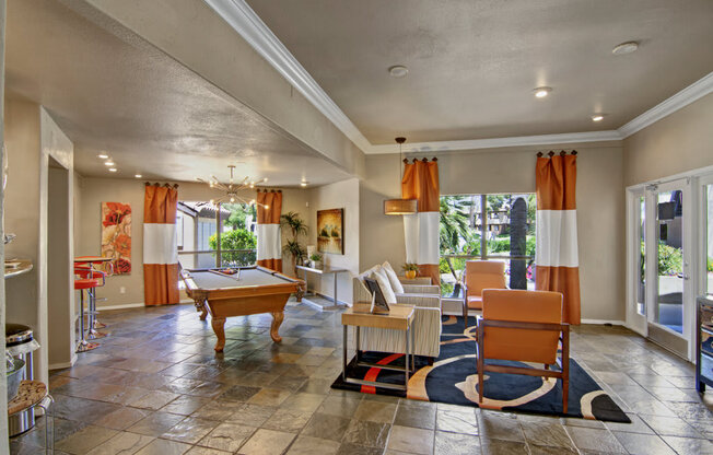 a clubhouse with a pool table and chairs