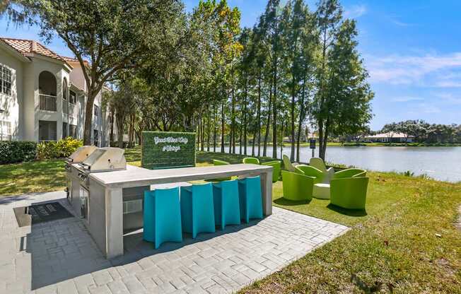 Community grilling and seating area by a pond at Hunters Green in Tampa, Florida.