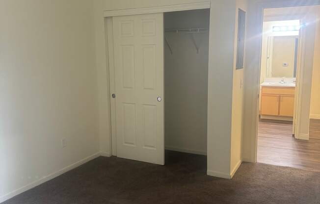 an empty living room with a closet and a bathroom