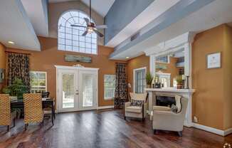 A living room with a fireplace and a dining table.