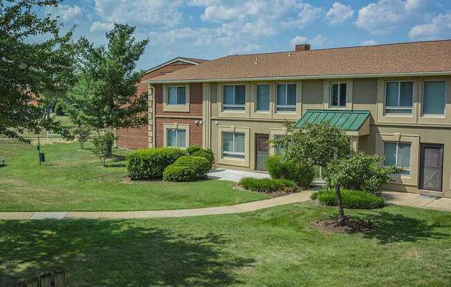 A building with a green awning and a tree in front of it.