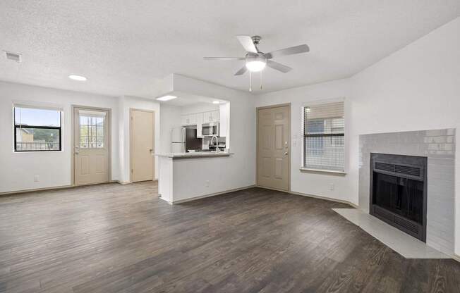 A living room with a fireplace and a ceiling fan.