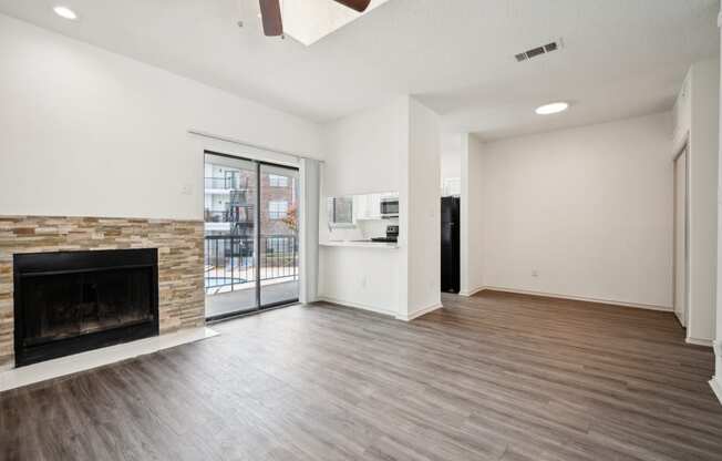 a living room with a fireplace and a door to a balcony