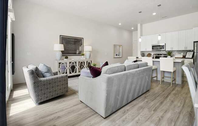 a living room and kitchen with hardwood floors and white cabinets at 200 City View, Provo, 84601