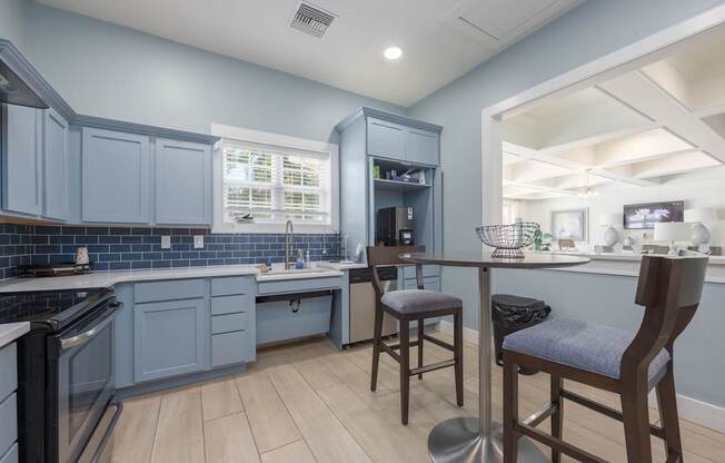 A kitchen with a blue cabinetry and wooden flooring.at Spring Creek Apartments, Crestview