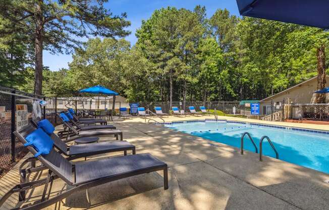 our resort style swimming pool is next to a row of lounge chairs
