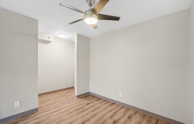 the living room of an empty house with a ceiling fan