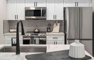 A modern kitchen with a stove, oven, and refrigerator.