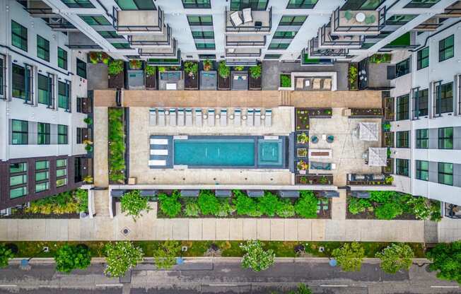 a birdseye view of a building with a swimming pool in the middle of it