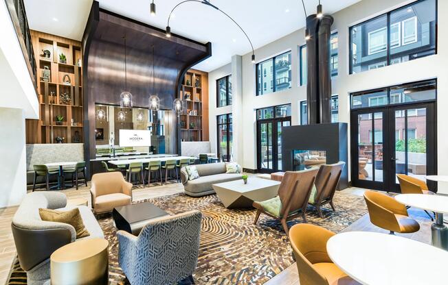 Grand community lounge with floor-to-ceiling windows, sculptural fixtures, and a mix of seating areas arranged for hosting, relaxing, and shared moments.