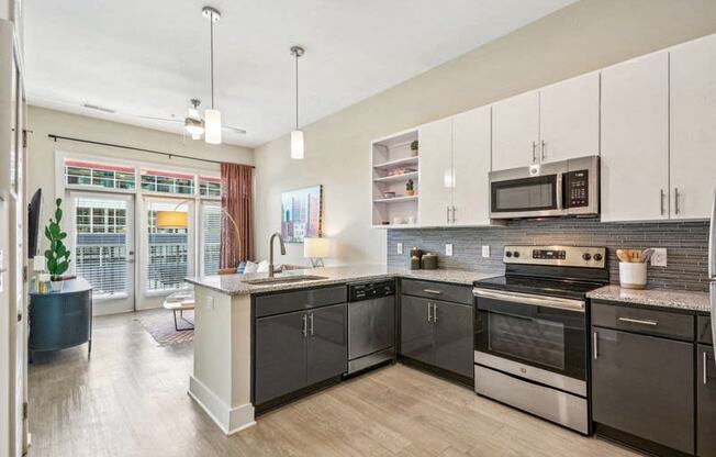 a large kitchen with stainless steel appliances and white cabinets at Link Apartments Innovation Quarter, Winston Salem