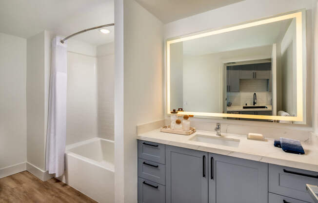 A bathroom with a white tub and sink.