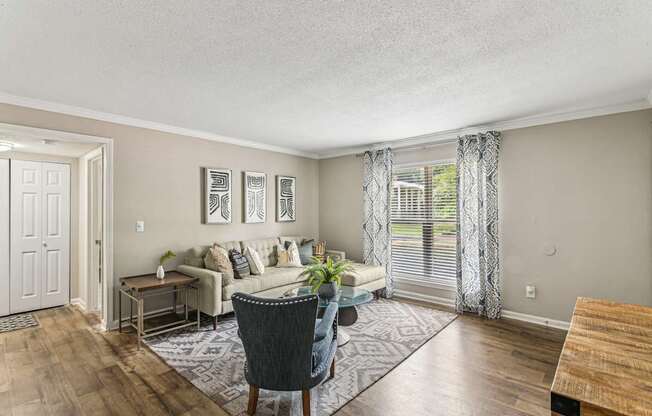 A living room with a couch, chair, and pictures on the wall.