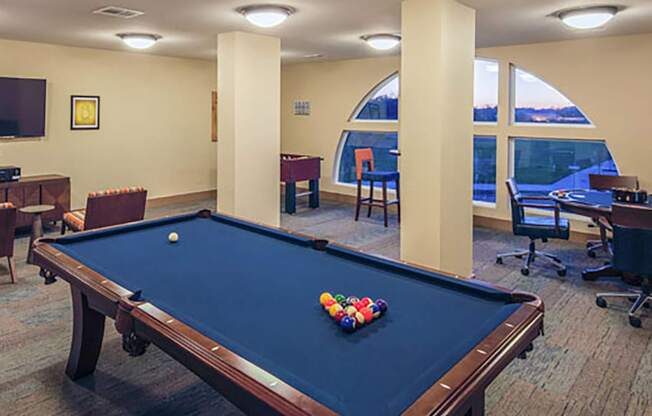 a game room with a pool table and chairs