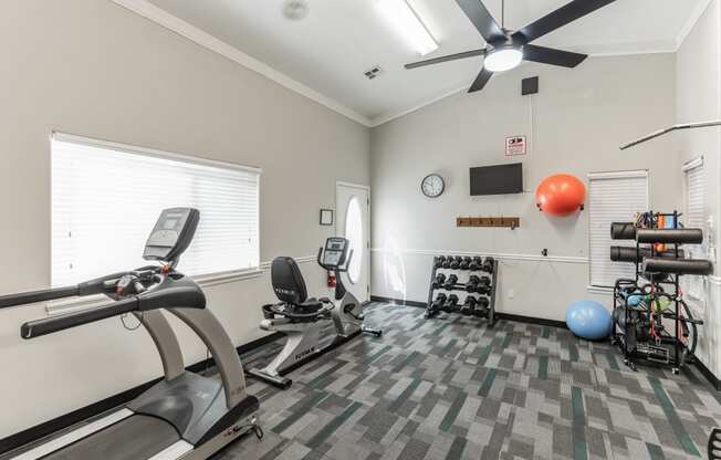 the gym with exercise equipment and a ceiling fan