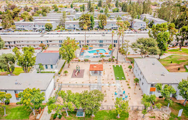 A large white building with a pool in the middle of a grassy area.