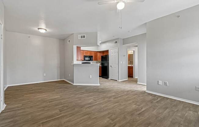 A spacious living room with wood flooring and a ceiling fan.