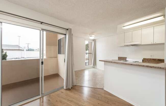 Patio Doors to Balcony and Kitchen with White Cabinets