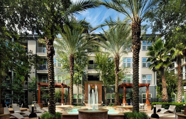 a fountain in the middle of a courtyard with palm trees