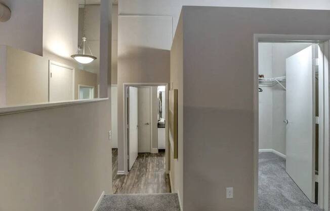 a hallway with a door to a bathroom and a closet