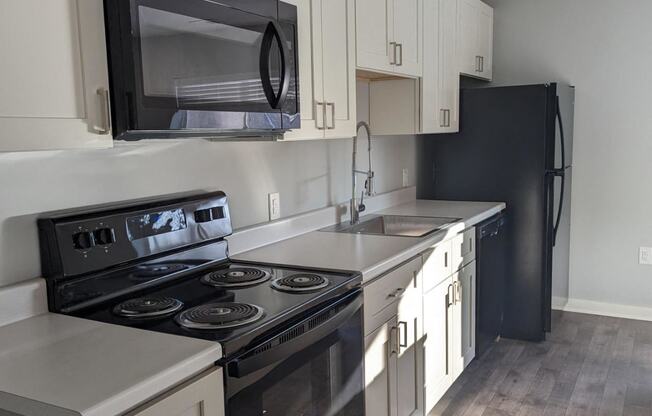 a kitchen with black appliances and white cabinets