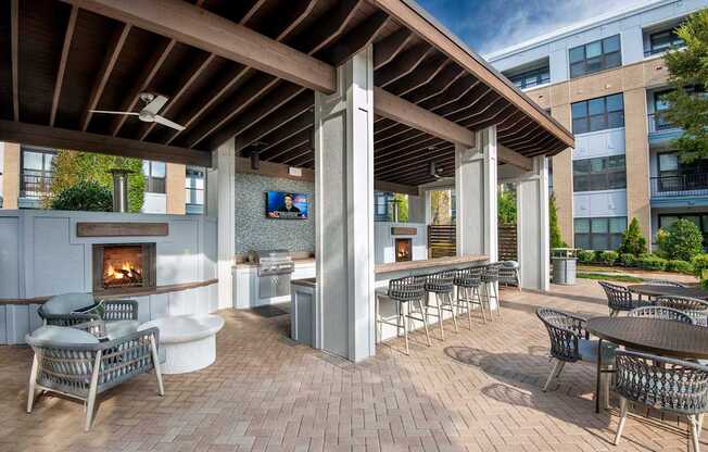 A patio with a fireplace and chairs.