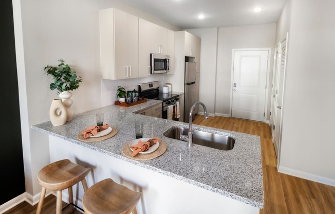 an open kitchen with a granite counter top and a sink