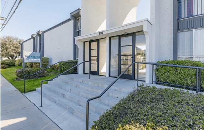the front entrance of a building with stairs and glass doorsat The Arches Apartments, LLC, El Cajon, CA 92021